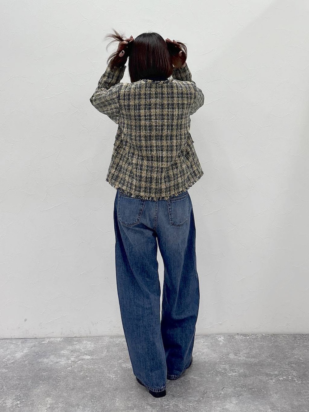 ブラック系のニット/セーター、ブラック系のブーツ、ブルー系のデニムパンツを着用したレディースの冬コーディネートの7枚目の写真