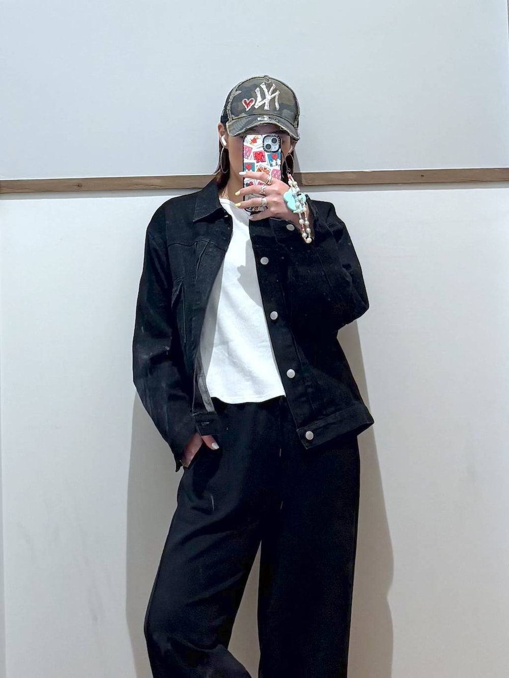 ブラック系のデニムジャケット、ブラック系のスウェットパンツ、ゴールド系のネックレスを着用したレディースの春コーディネートの3枚目の写真