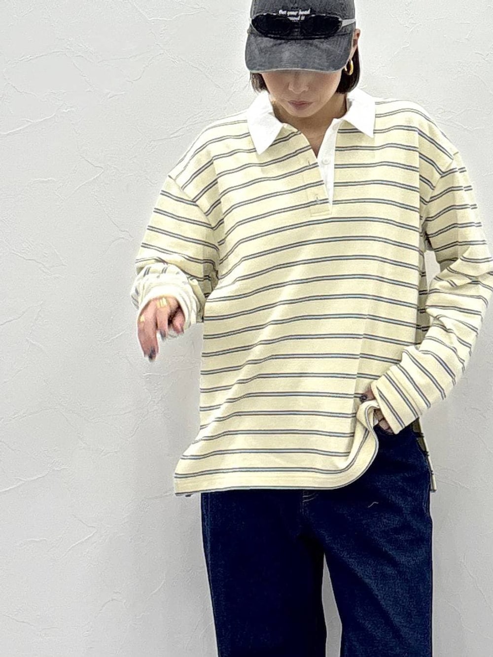 ブラック系のスニーカー、イエロー系のスウェット、ゴールド系のピアス(両耳用)を着用したレディースの冬コーディネートの3枚目の写真