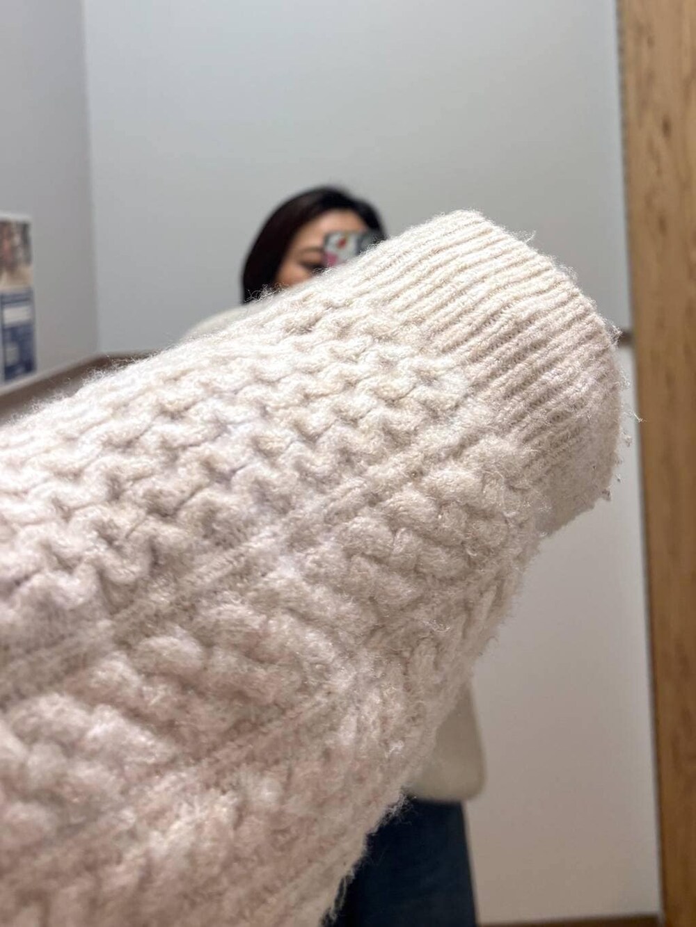 ブラウン系のブーツ、ホワイト系のニット/セーター、ブルー系のデニムパンツを着用したレディースの冬コーディネートの4枚目の写真