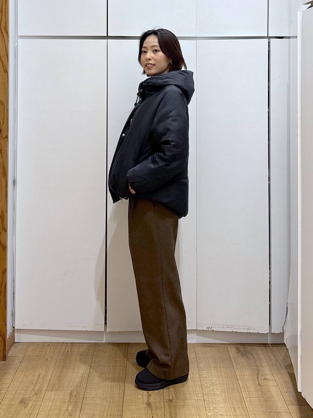 ブラック系のダウンジャケット/コート、ブラウン系のその他パンツ、ホワイト系のTシャツ/カットソーを着用したレディースの冬コーディネートの3枚目の写真