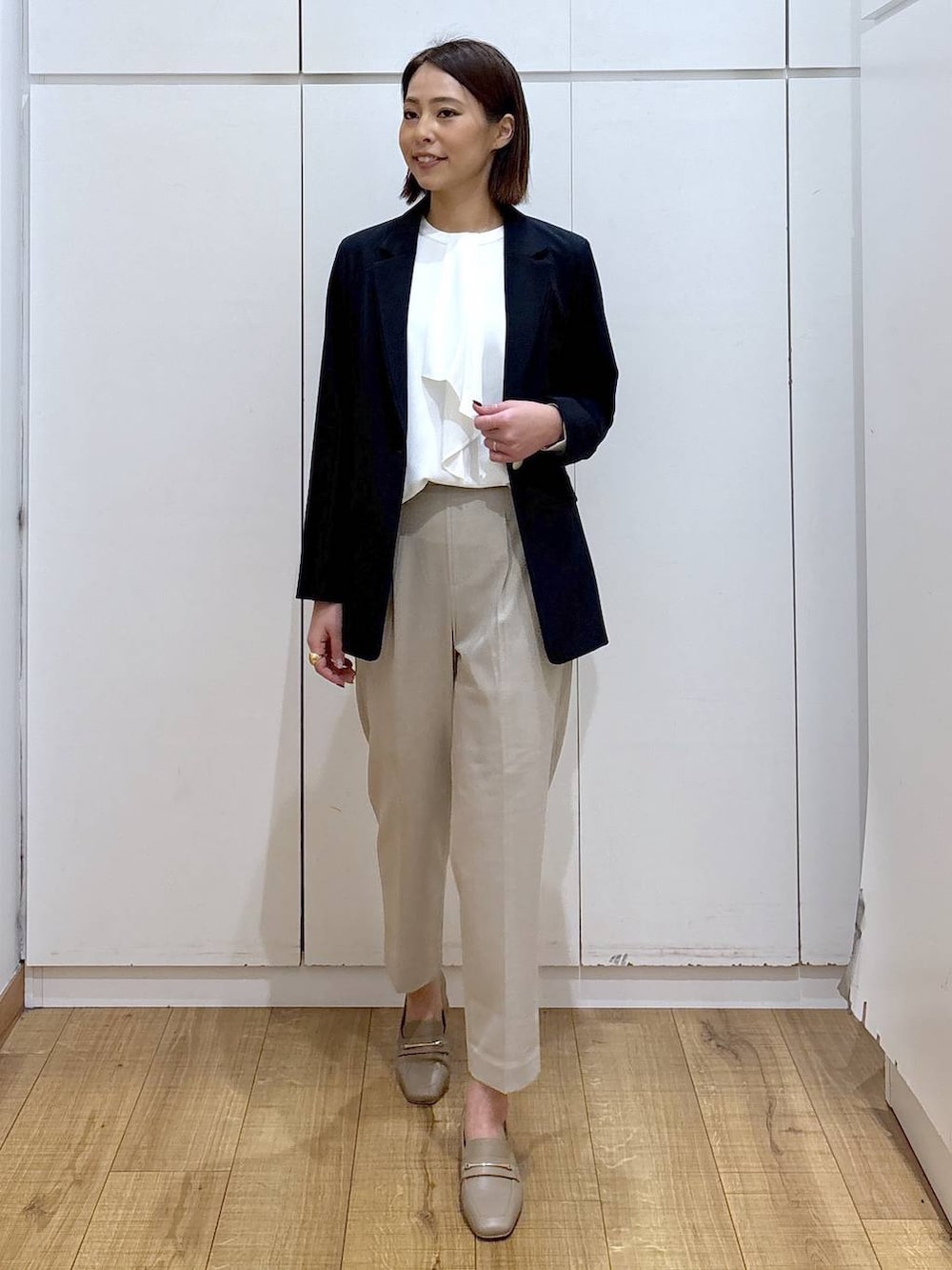 ベージュ系のローファー、ベージュ系のスラックス、ホワイト系のシャツ/ブラウスを着用したレディースの冬コーディネートの2枚目の写真