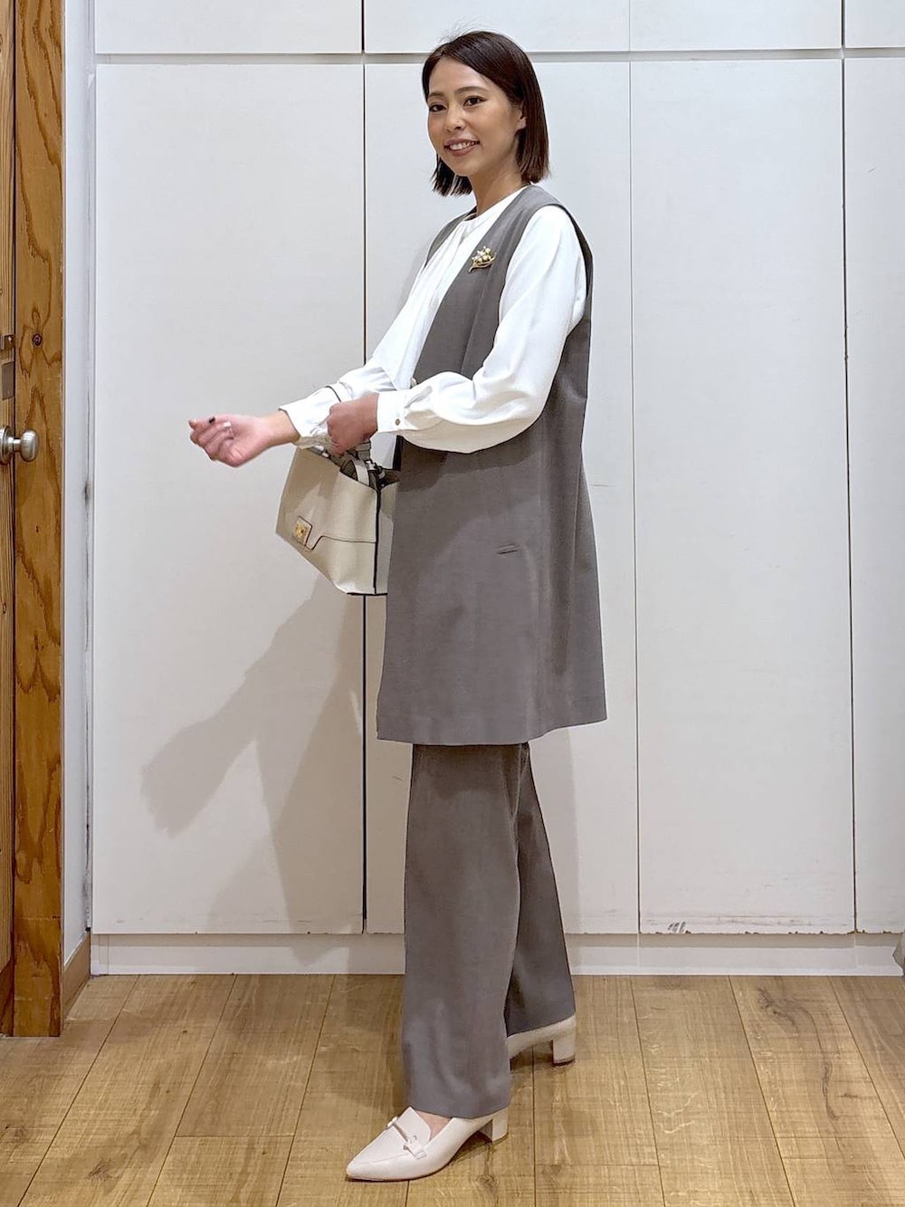 ブラウン系のスラックス、ホワイト系のシャツ/ブラウス、ブラウン系のその他アウターを着用したレディースの冬コーディネートの4枚目の写真