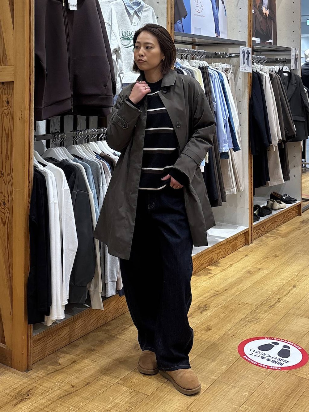 ブラウン系のステンカラーコート、ブルー系のデニムパンツを着用したレディースの冬コーディネートの7枚目の写真