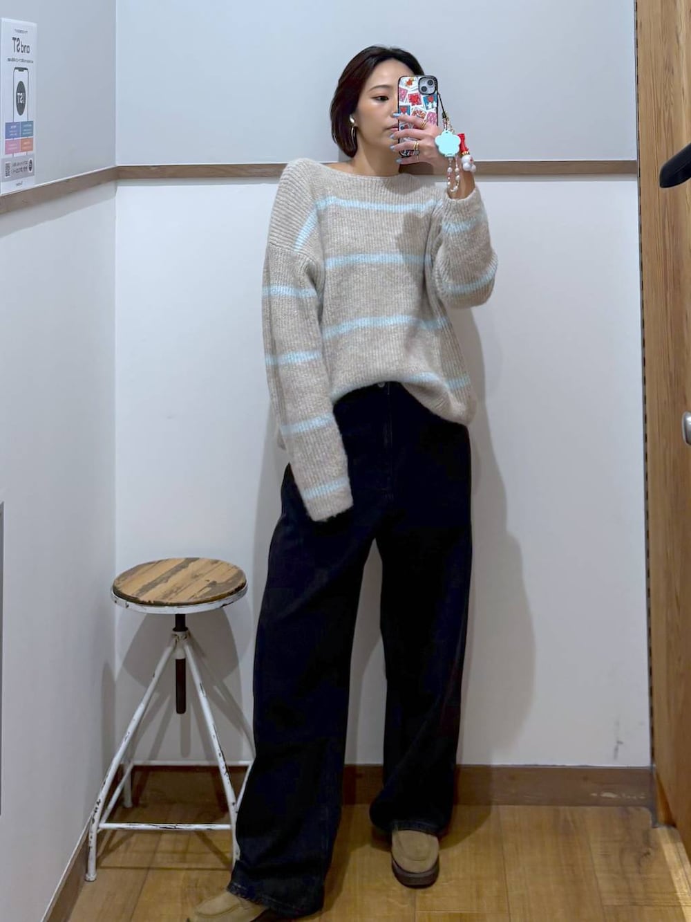 ブラック系のデニムパンツ、ベージュ系のローファー、ベージュ系のニット/セーターを着用したレディースの冬コーディネートの4枚目の写真