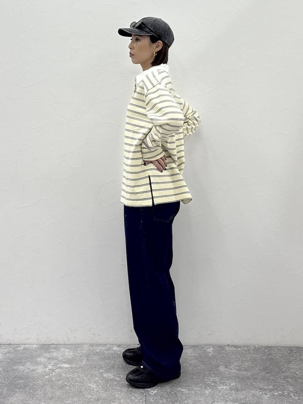 ブラック系のスニーカー、イエロー系のスウェット、ゴールド系のピアス(両耳用)を着用したレディースの冬コーディネートの5枚目の写真