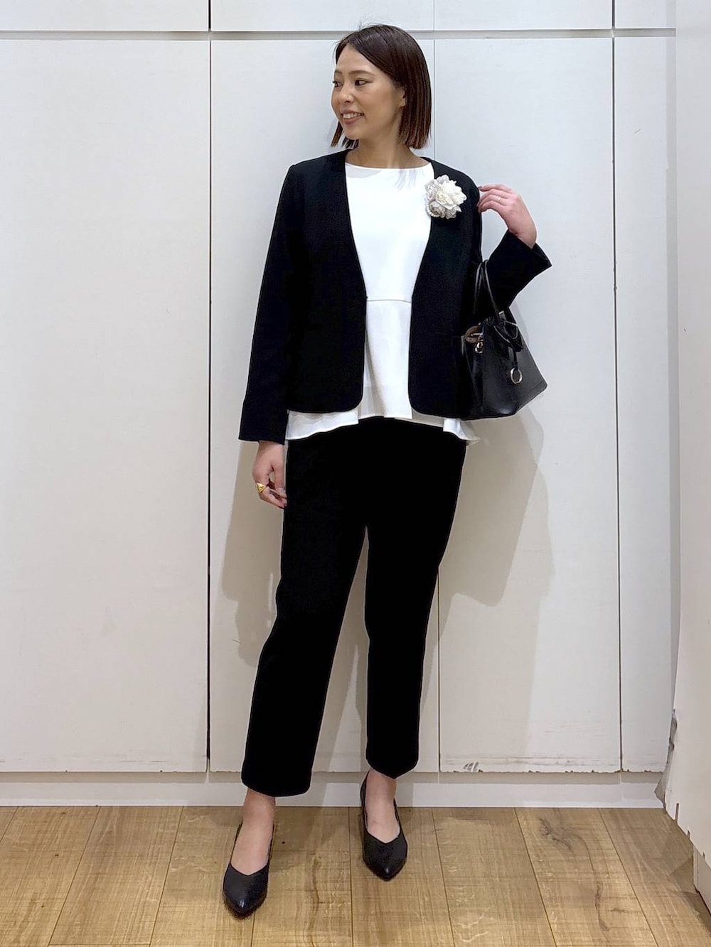 ブラック系のショルダーバッグ、ブラック系のパンプス、ブラック系のセットアップを着用したレディースの冬コーディネートの2枚目の写真