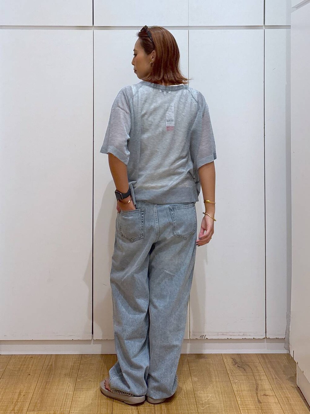 ブルー系のデニムパンツ、ホワイト系のタンクトップ、ベージュ系のサンダルを着用したレディースの夏コーディネートの4枚目の写真