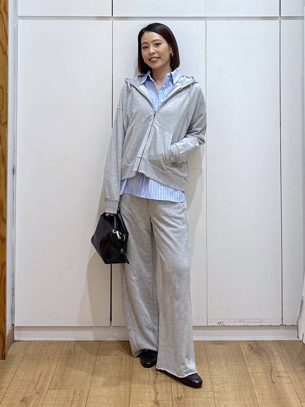 ブラック系のローファー、ブラック系のショルダーバッグ、グレー系のスウェットパンツを着用したレディースの冬コーディネートの2枚目の写真