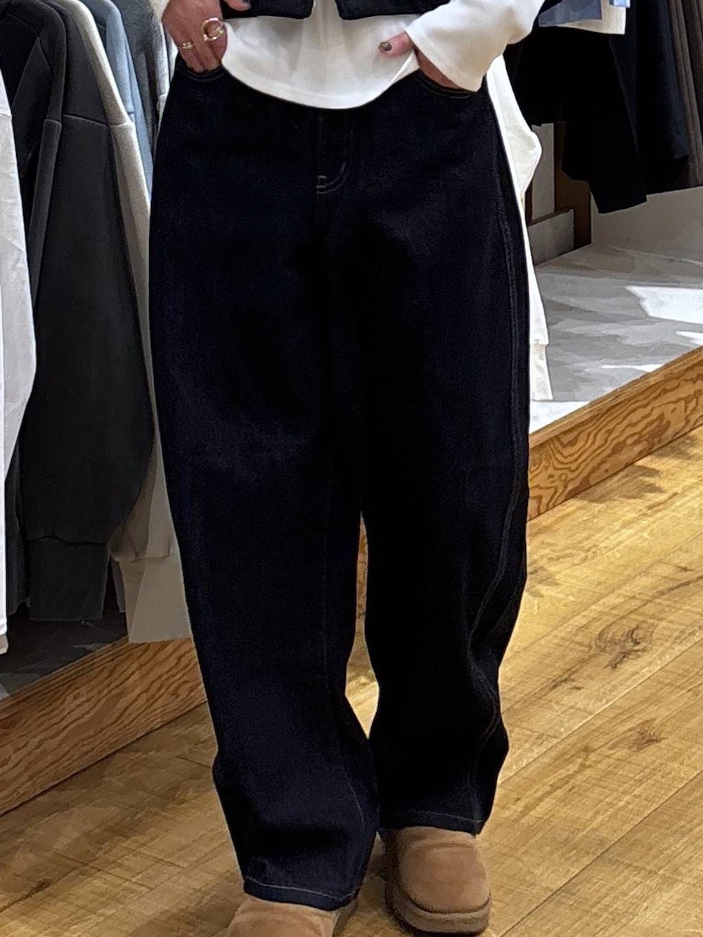 ブルー系のデニムパンツ、ブラック系のベストを着用したレディースの冬コーディネートの7枚目の写真