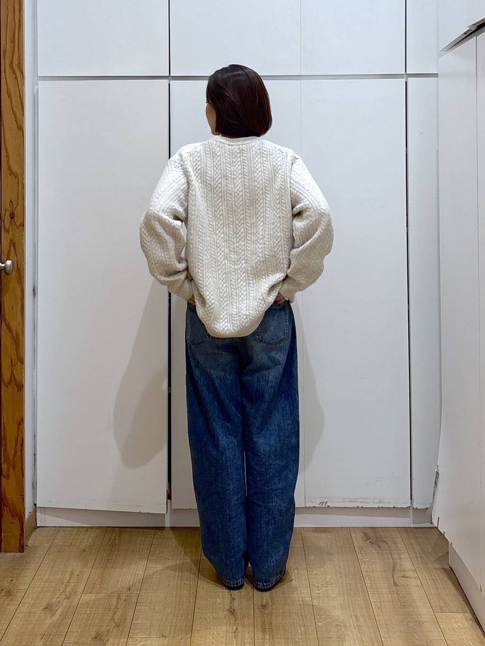 ブラウン系のブーツ、ホワイト系のニット/セーター、ブルー系のデニムパンツを着用したレディースの冬コーディネートの6枚目の写真