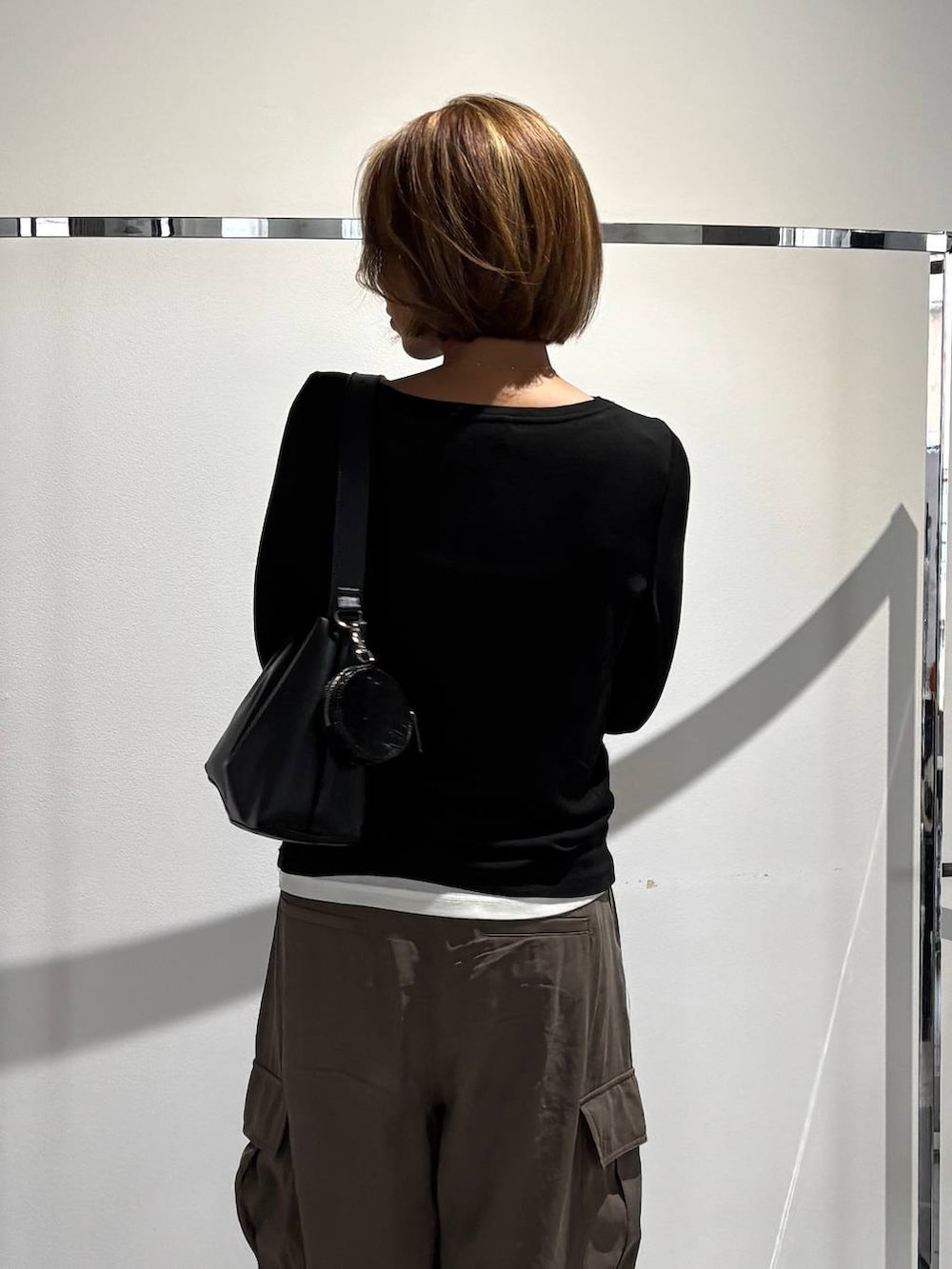 グリーン系のその他パンツ、ホワイト系のTシャツ/カットソー、ブラック系のTシャツ/カットソーを着用したレディースの秋コーディネートの3枚目の写真