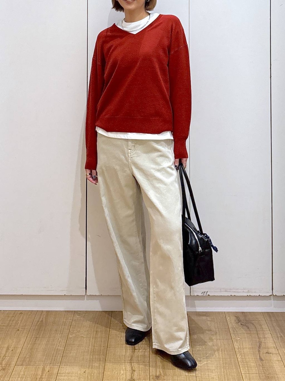 ブラック系のボストンバッグ、ベージュ系のデニムパンツ、ホワイト系のTシャツ/カットソーを着用したレディースの秋コーディネートの5枚目の写真