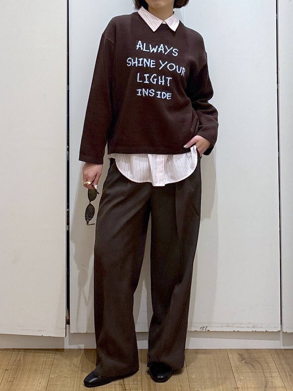 ピンク系のシャツ/ブラウス、ブラック系のブーツ、ブラウン系のニット/セーターを着用したレディースの冬コーディネートの2枚目の写真