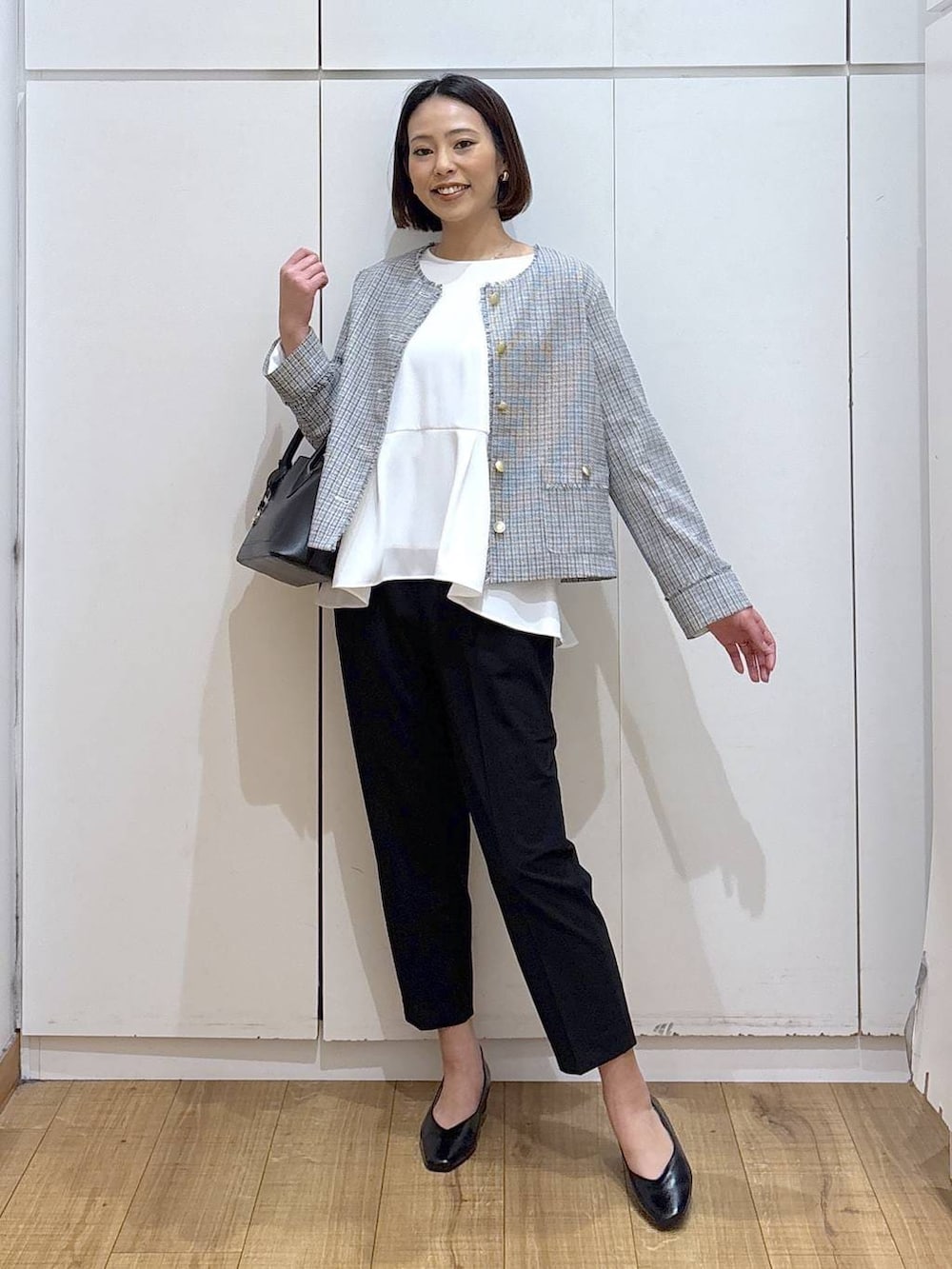 ブラック系のショルダーバッグ、ブラック系のパンプス、ブラック系のスラックスを着用したレディースの冬コーディネートの2枚目の写真