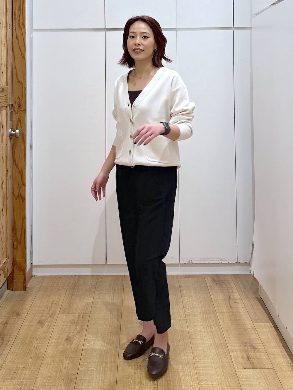 ブラウン系のローファー、ブラック系のスラックス、ベージュ系のカーディガン/ボレロを着用したレディースの春コーディネートの3枚目の写真