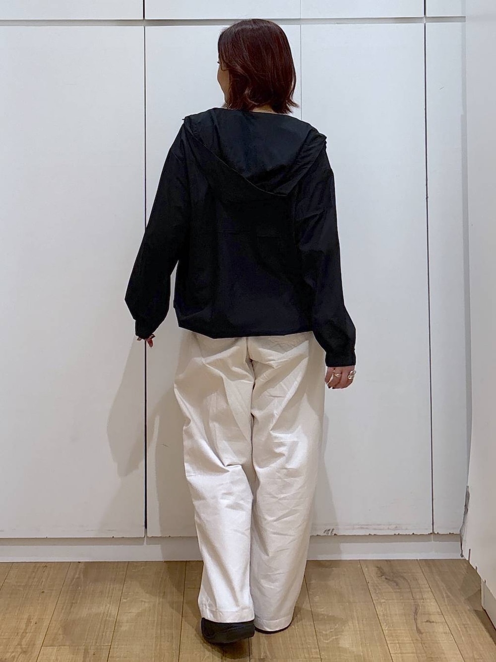 ブラック系のマウンテンパーカー、ベージュ系のその他パンツ、ゴールド系のネックレスを着用したレディースの春コーディネートの4枚目の写真