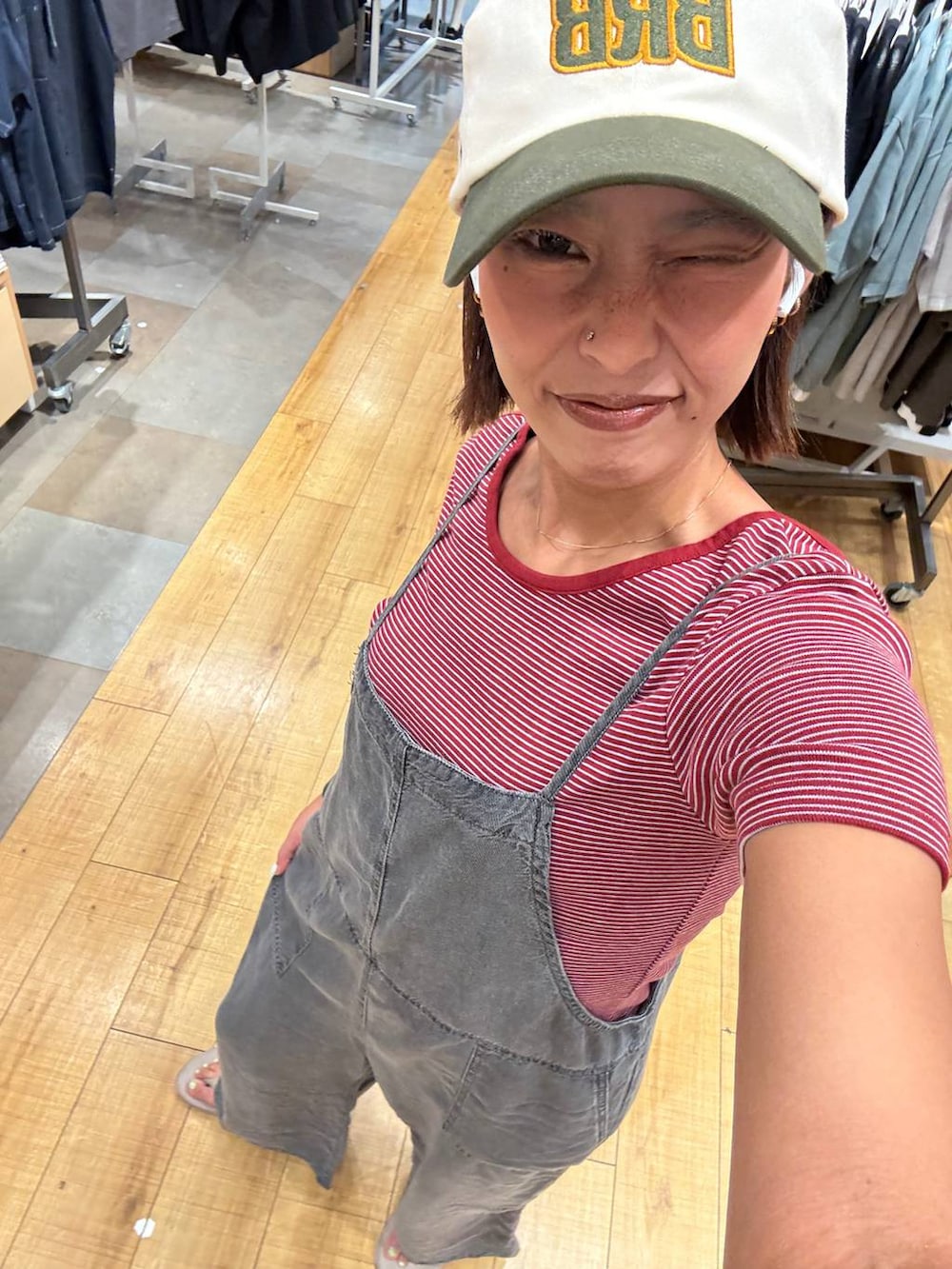 ブラック系のサロペット/オーバーオール、レッド系のTシャツ/カットソー、ベージュ系のサンダルを着用したレディースの夏コーディネートの4枚目の写真