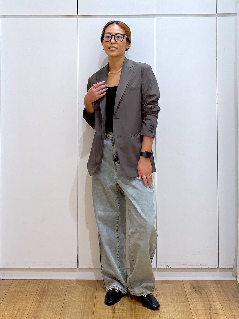 ブラック系のローファー、ブラック系のキャミソール、ブルー系のデニムパンツを着用したレディースの秋コーディネートの4枚目の写真