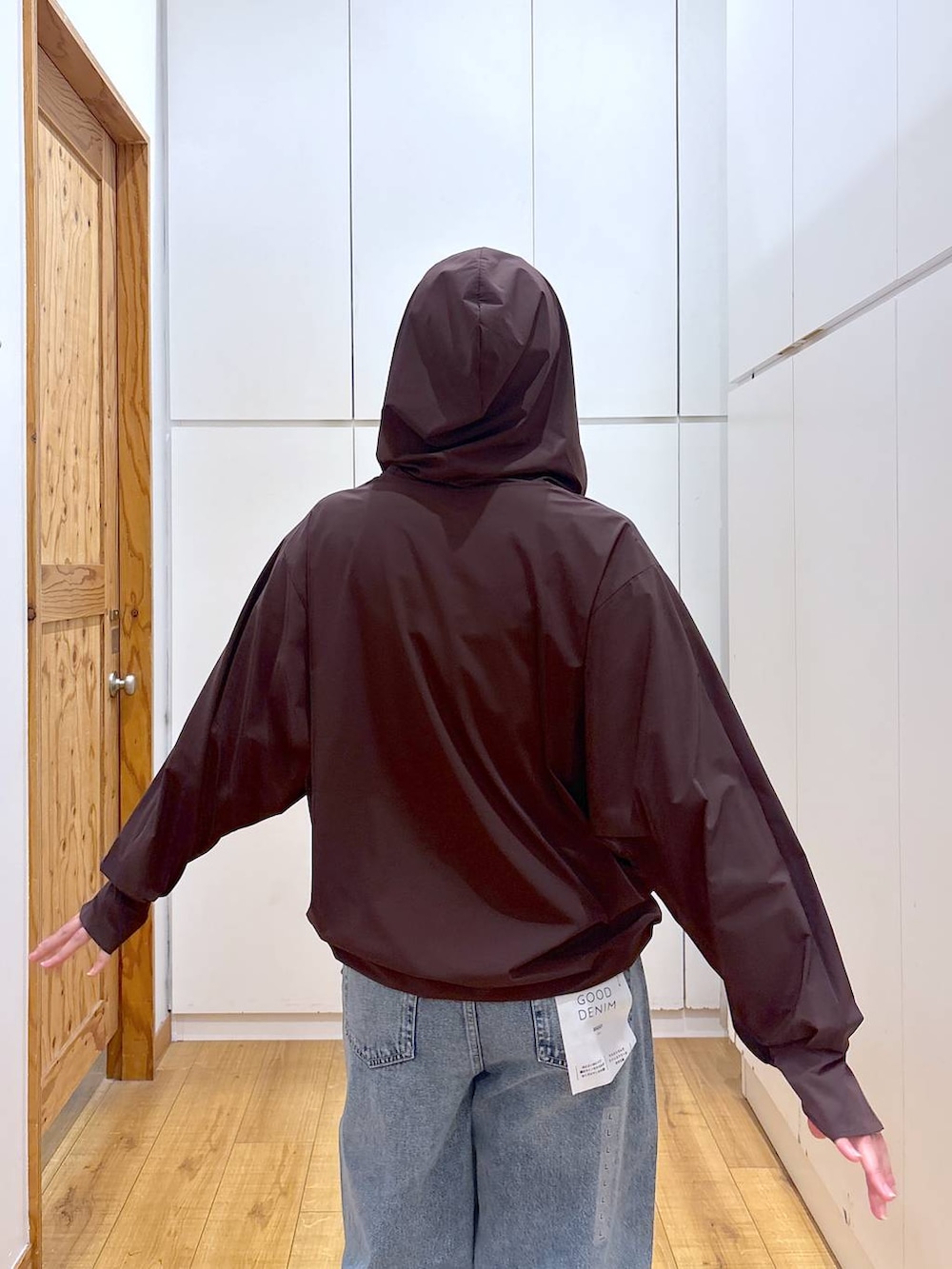 ブルー系のデニムパンツ、ブラウン系のマウンテンパーカー、ブルー系のキャップを着用したレディースの夏コーディネートの6枚目の写真