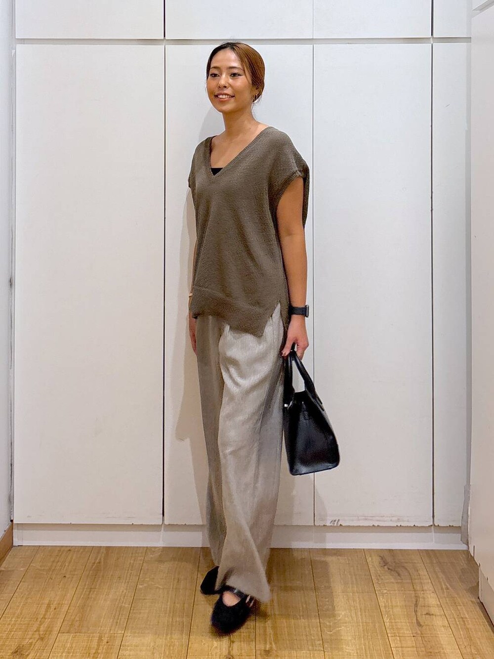 ブラック系のキャミソール、ブラウン系のベスト、ベージュ系のその他パンツを着用したレディースの秋コーディネートの3枚目の写真