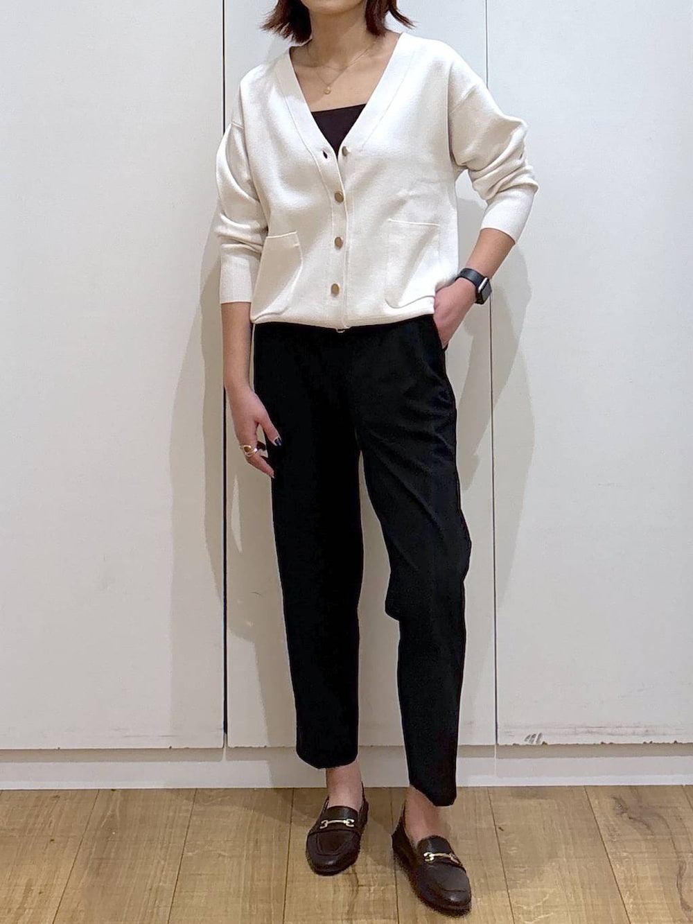 ブラウン系のローファー、ブラック系のスラックス、ベージュ系のカーディガン/ボレロを着用したレディースの春コーディネートの2枚目の写真