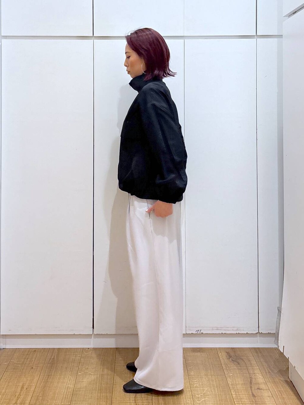 ベージュ系のトレンチコート、グレー系のその他パンツ、ホワイト系のブルゾンを着用したレディースの春コーディネートの6枚目の写真