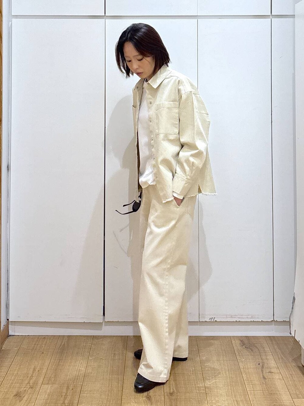 ブラック系のローファー、ホワイト系のTシャツ/カットソー、ベージュ系のシャツ/ブラウスを着用したレディースの冬コーディネートの2枚目の写真