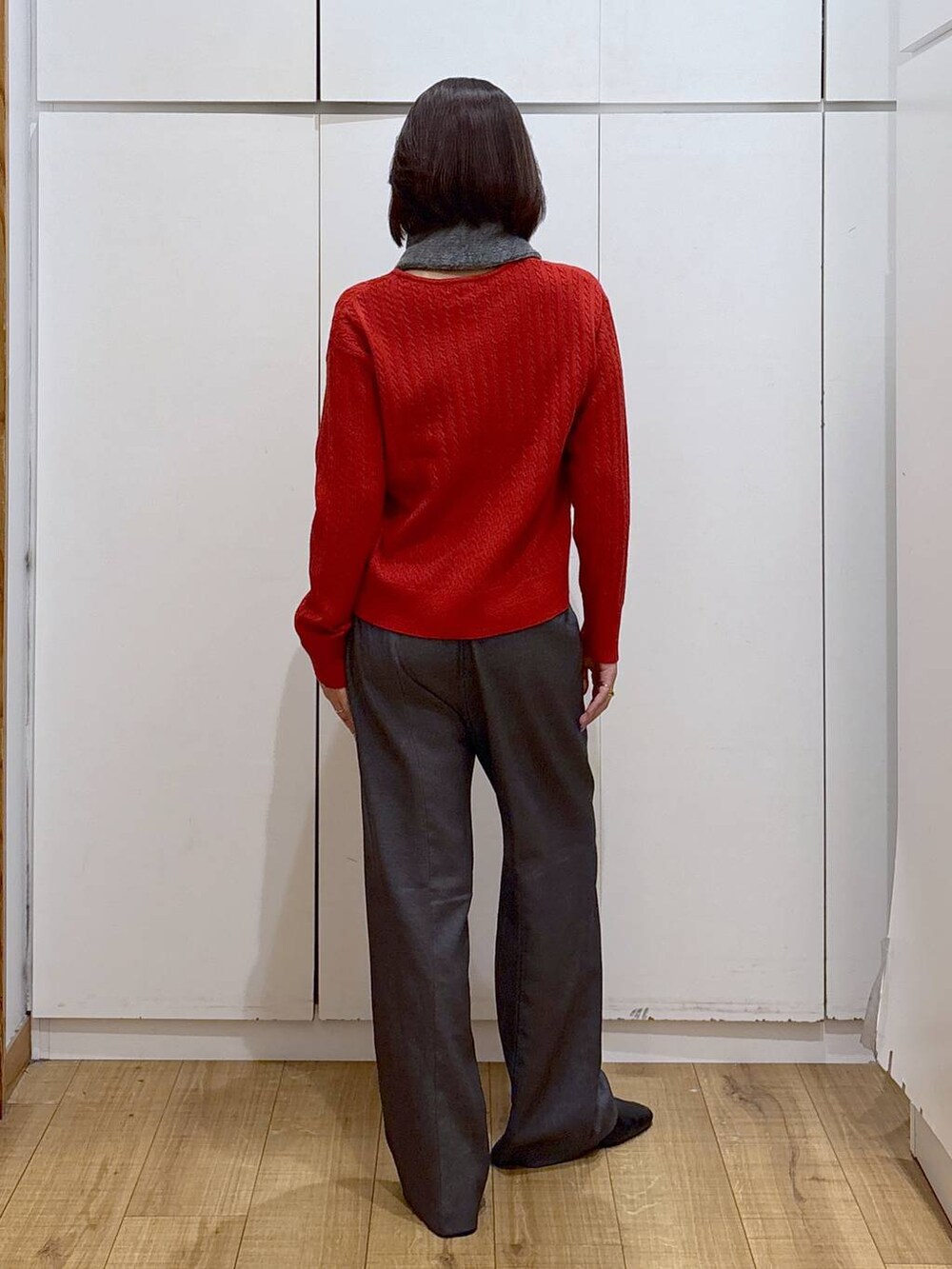 グレー系のその他パンツ、ブラック系のブーツ、レッド系のニット/セーターを着用したレディースの秋コーディネートの3枚目の写真