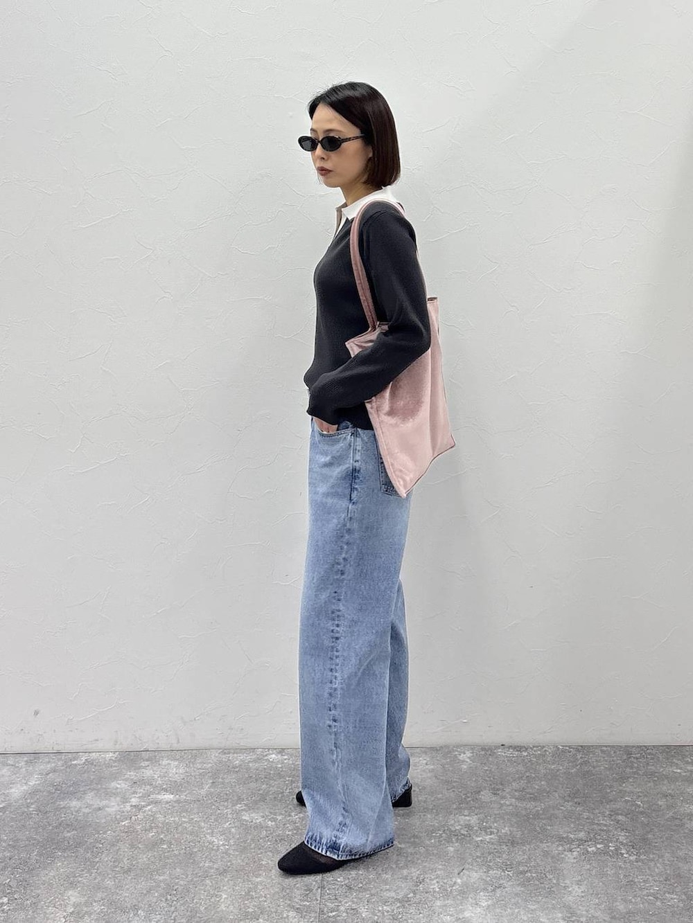 ピンク系のトートバッグ、グレー系のニット/セーター、ゴールド系のピアス（両耳用）を着用したレディースの冬コーディネートの5枚目の写真