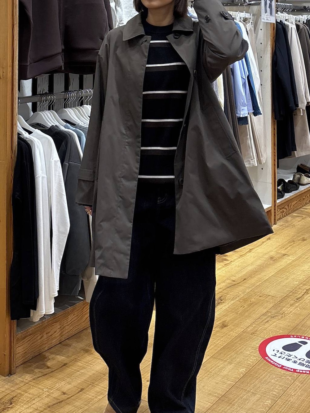 ブラウン系のステンカラーコート、ブルー系のデニムパンツを着用したレディースの冬コーディネートの4枚目の写真