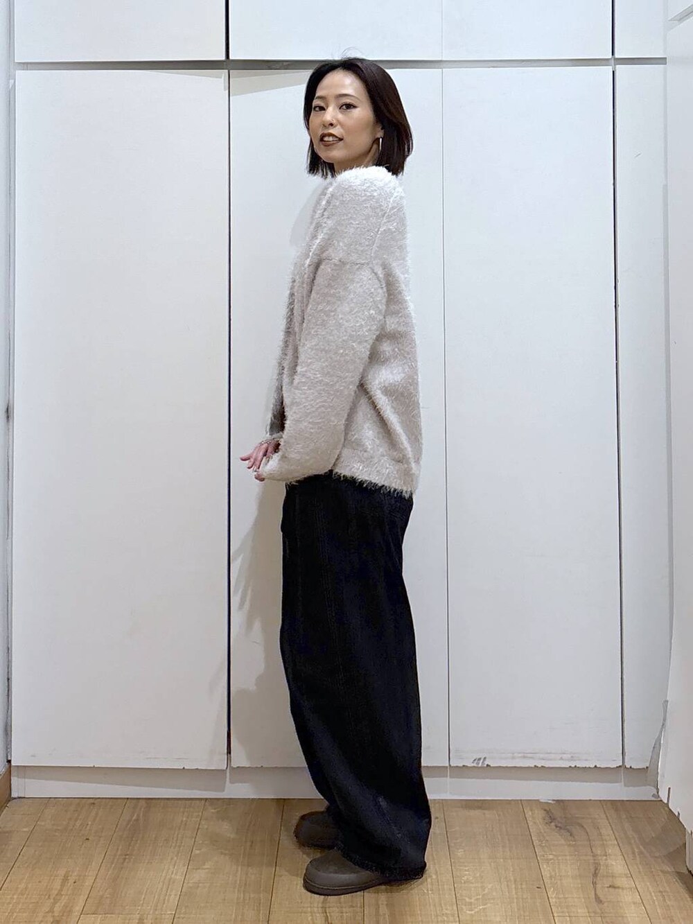 ブラック系のデニムパンツ、ベージュ系のカーディガン/ボレロ、グリーン系のその他シューズを着用したレディースの秋コーディネートの3枚目の写真