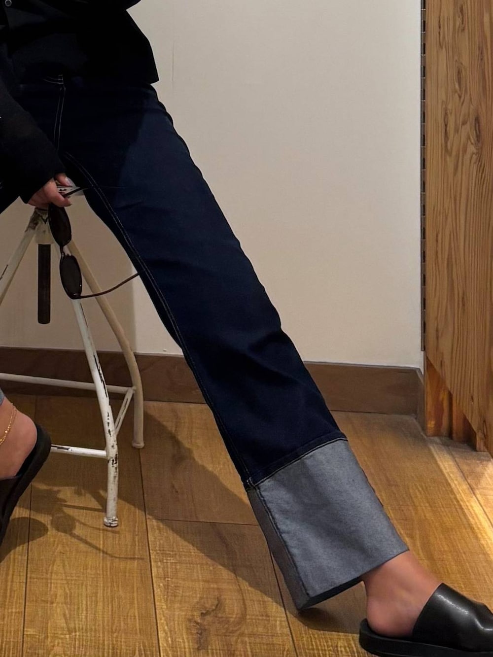 ブルー系のデニムパンツ、ブラック系のキャミソール、ブラック系のカーディガン/ボレロを着用したレディースの秋コーディネートの3枚目の写真