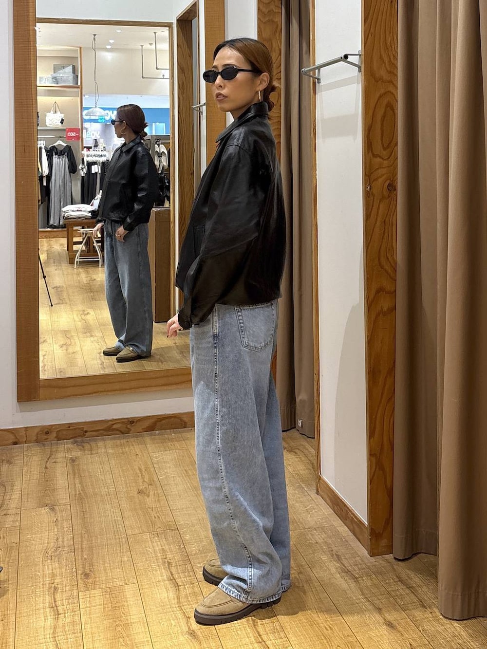 ブラック系のブルゾン、ブルー系のデニムパンツ、ベージュ系のローファーを着用したレディースの秋コーディネートの4枚目の写真