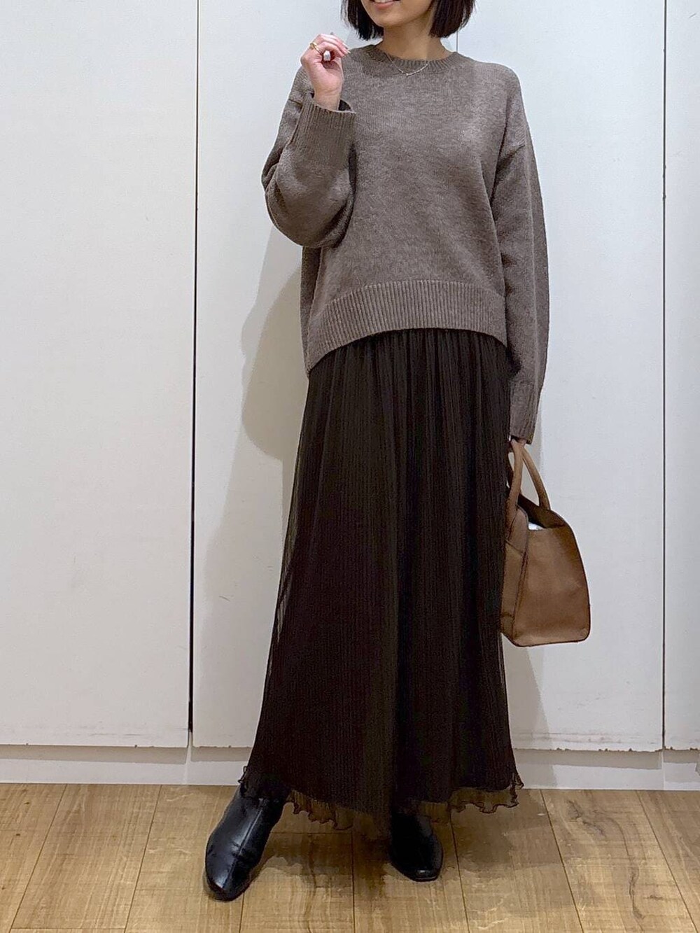 ベージュ系のショルダーバッグ、ブラウン系のワンピース、ブラック系のブーツを着用したレディースの秋コーディネートの4枚目の写真