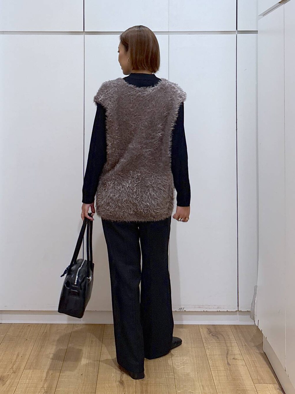 ブラック系のボストンバッグ、ブラック系のニット/セーター、ブラック系のその他パンツを着用したレディースの秋コーディネートの4枚目の写真