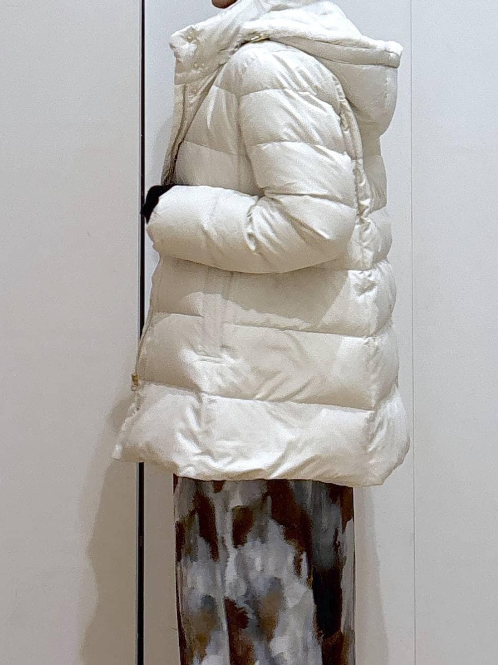 ベージュ系のダウンジャケット/コート、ブラック系のニット/セーター、ブラック系のブーツを着用したレディースの冬コーディネートの4枚目の写真