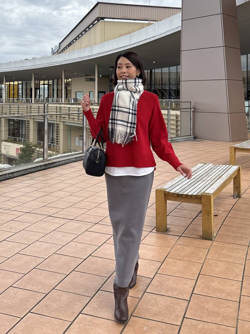 ブラウン系のチェスターコート、グレー系のスカート、ホワイト系のTシャツ/カットソーを着用したレディースの秋コーディネートの6枚目の写真