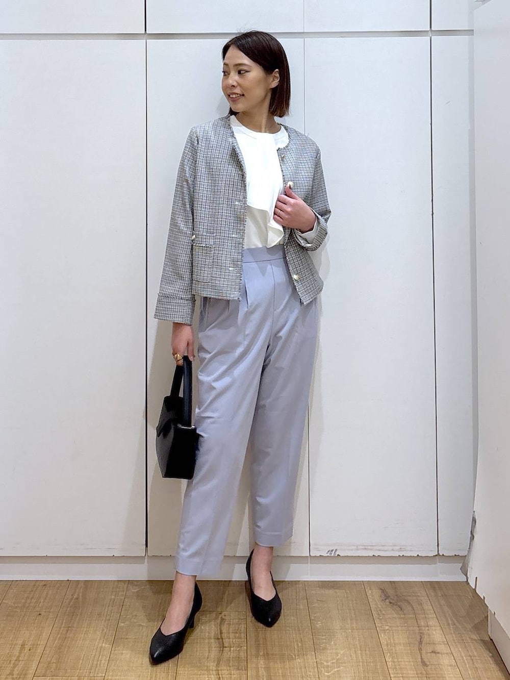 ブラック系のパンプス、ブルー系のスラックス、ホワイト系のシャツ/ブラウスを着用したレディースの冬コーディネートの2枚目の写真