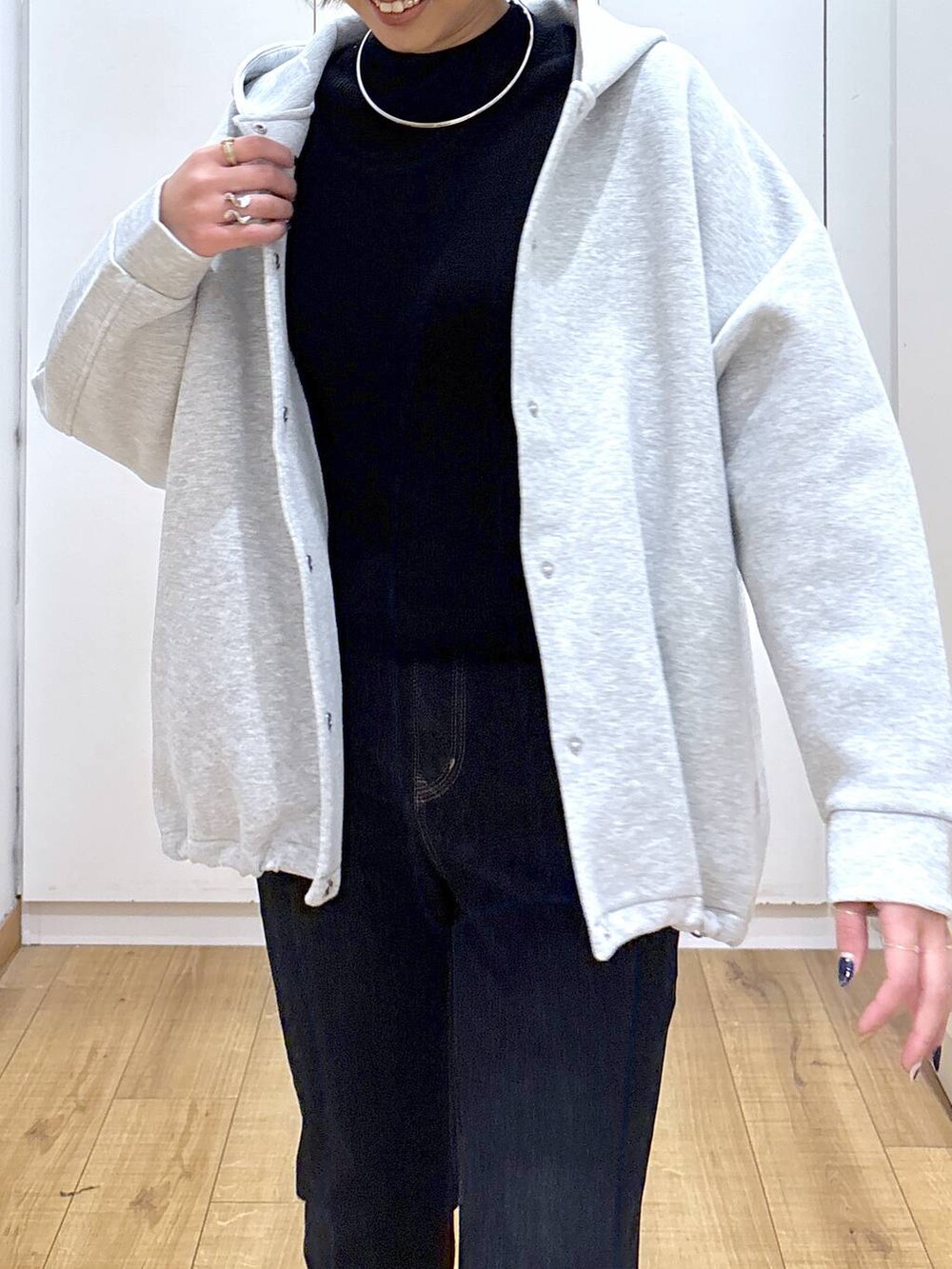 ブルー系のデニムパンツ、ブラック系のニット/セーター、グレー系のブルゾンを着用したレディースの秋コーディネートの5枚目の写真