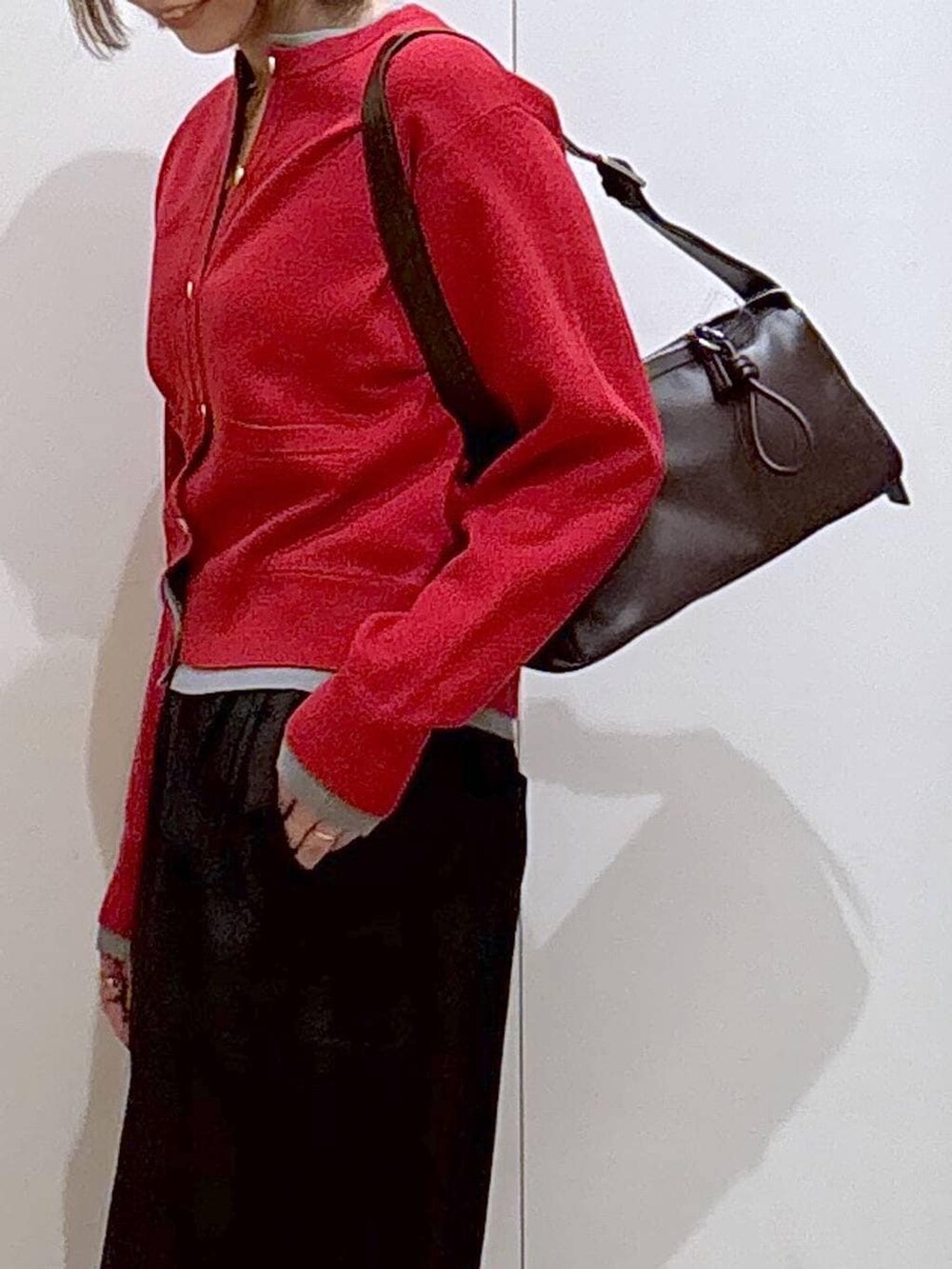 ブラック系のローファー、レッド系のカーディガン/ボレロ、ブラウン系のショルダーバッグを着用したレディースの冬コーディネートの6枚目の写真