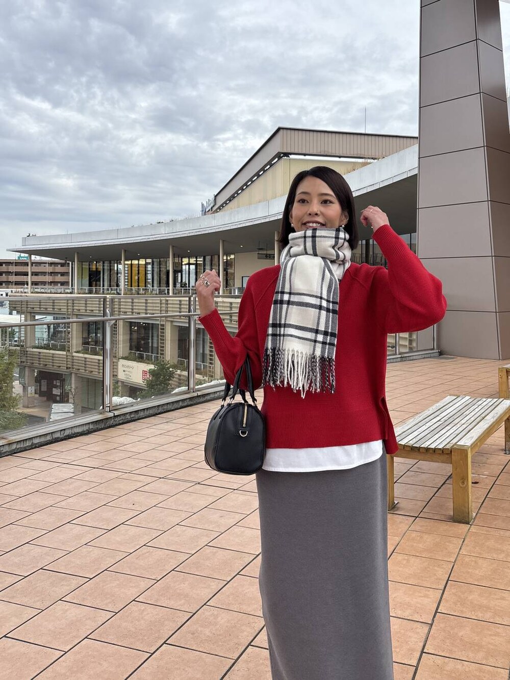 ブラウン系のチェスターコート、グレー系のスカート、ホワイト系のTシャツ/カットソーを着用したレディースの秋コーディネートの8枚目の写真