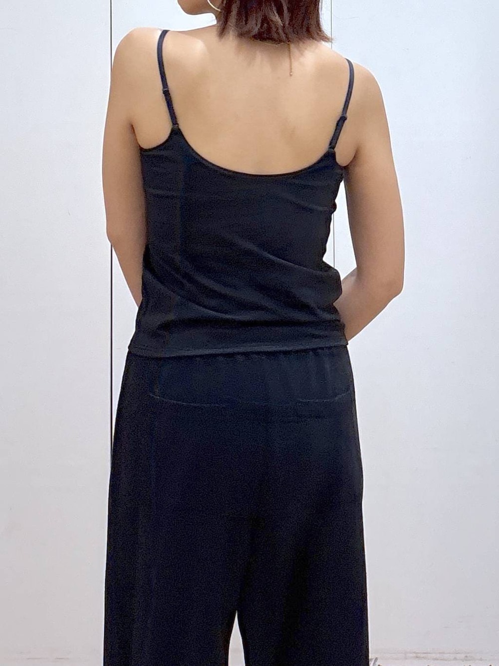 ブラック系のキャミソール、ブラック系のスウェットパンツ、ゴールド系のネックレスを着用したレディースの春コーディネートの5枚目の写真