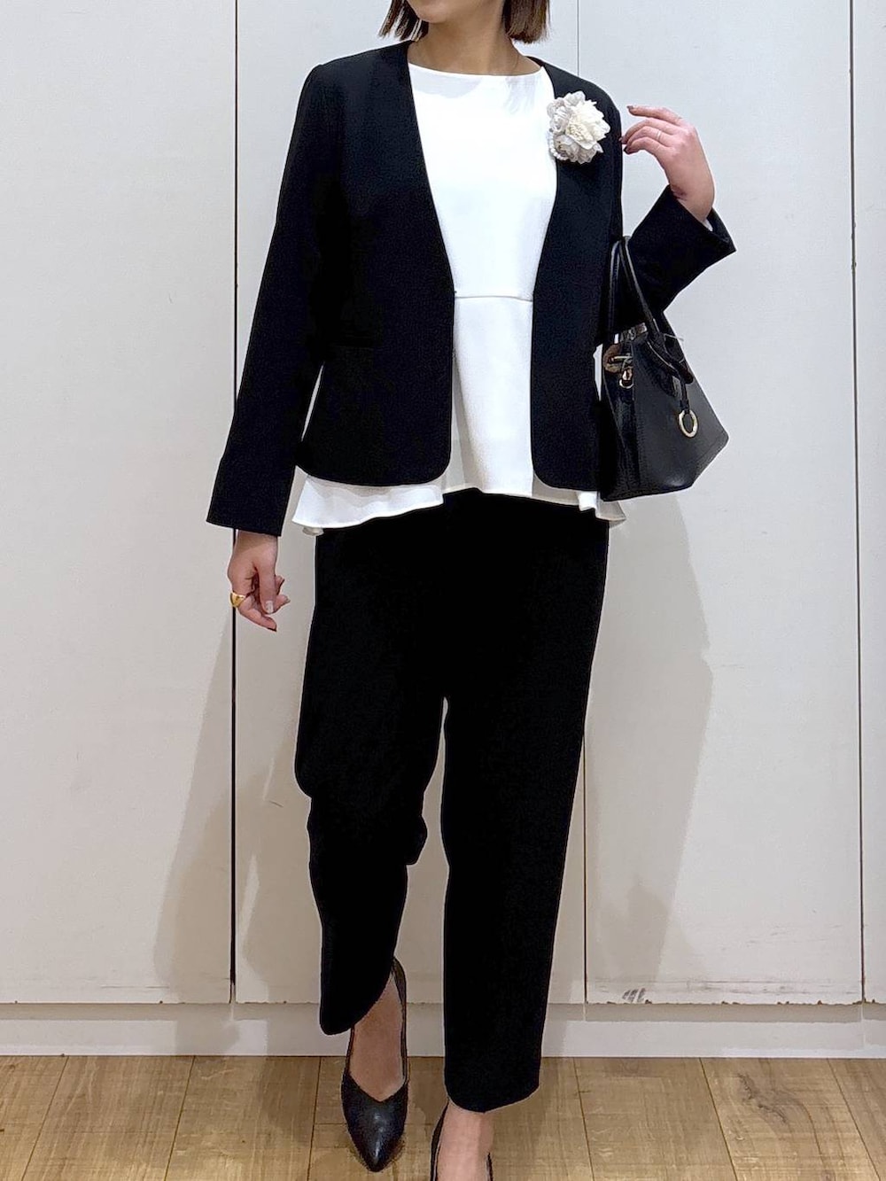 ブラック系のショルダーバッグ、ブラック系のパンプス、ブラック系のセットアップを着用したレディースの冬コーディネートの5枚目の写真