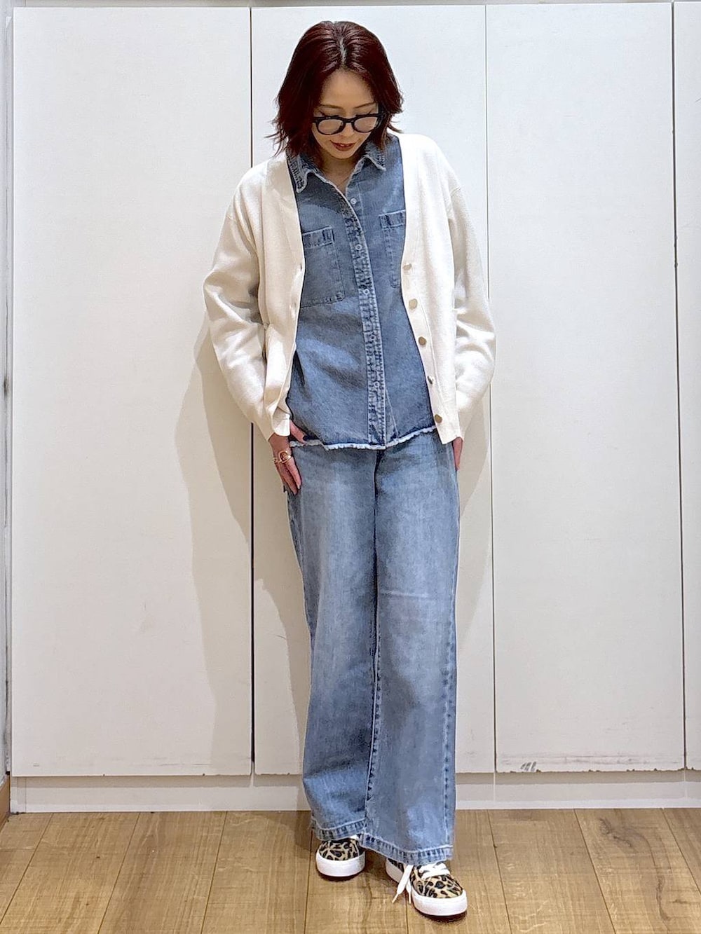 ブルー系のデニムパンツ、ベージュ系のカーディガン/ボレロ、ブルー系のシャツ/ブラウスを着用したレディースの春コーディネートの3枚目の写真