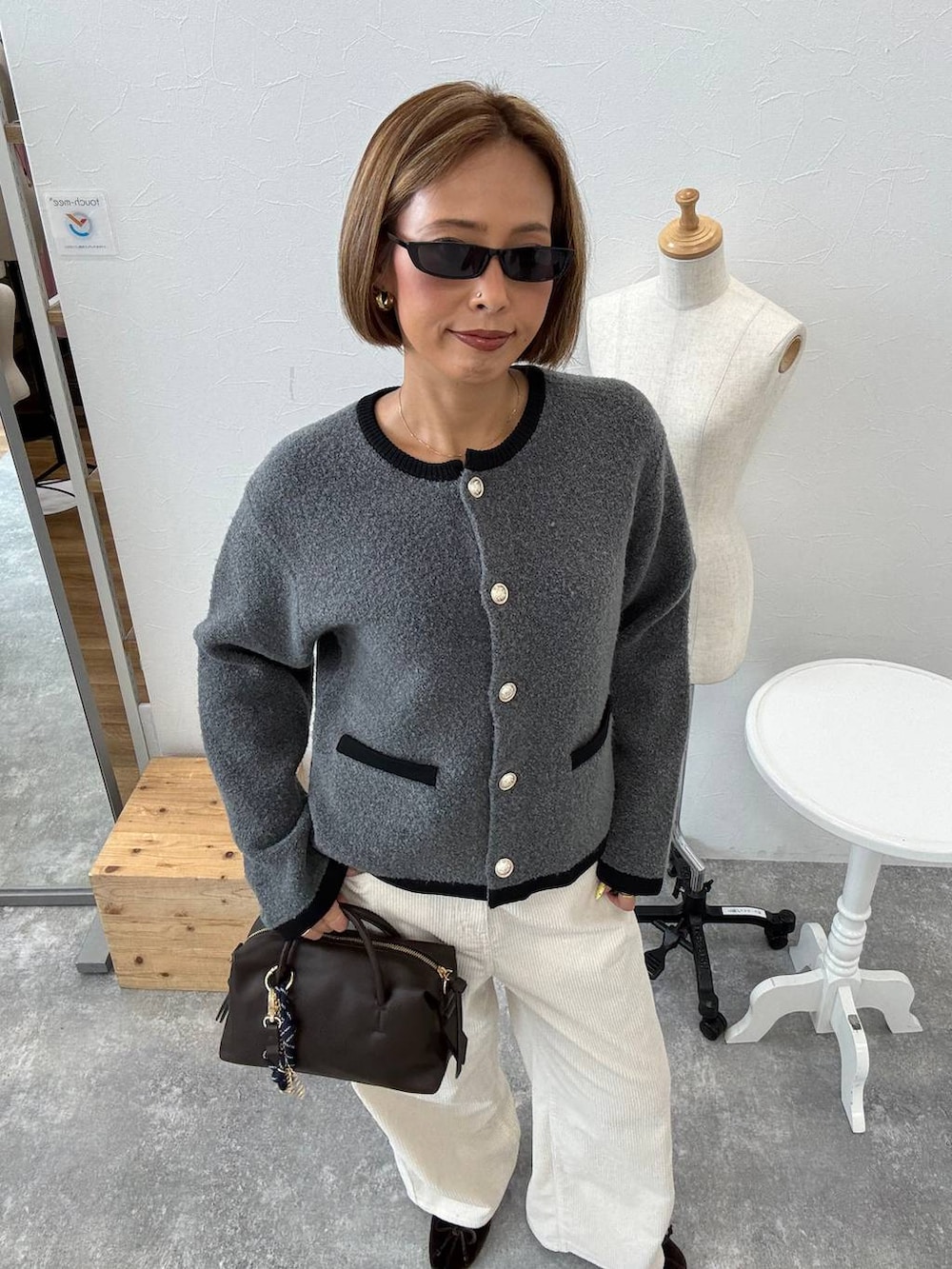 ホワイト系のその他パンツ、グレー系のノーカラージャケット、ブラウン系のボストンバッグを着用したレディースの秋コーディネートの3枚目の写真