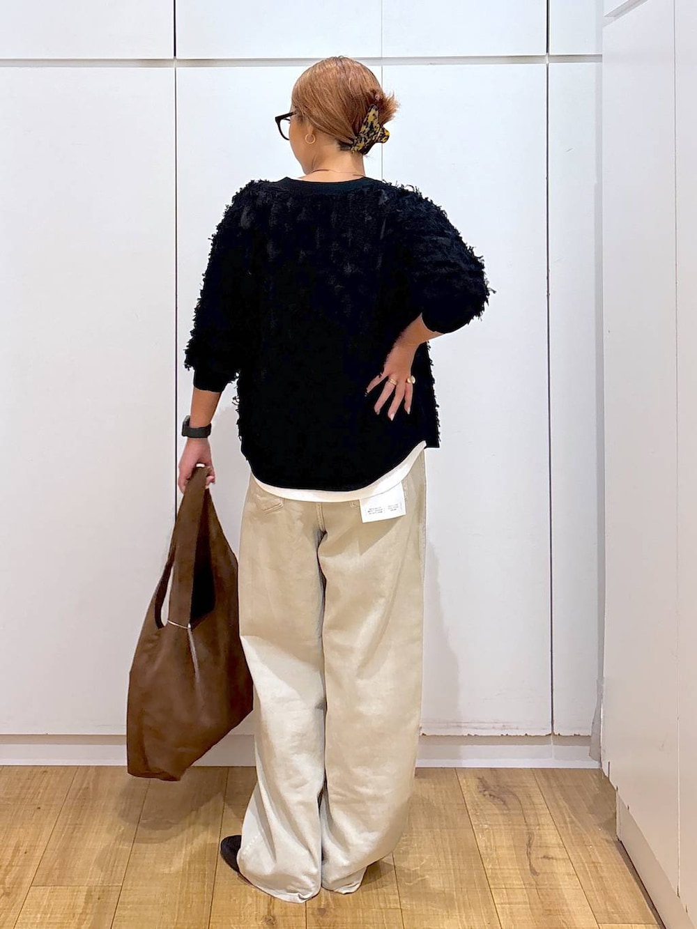 ブラック系のローファー、ホワイト系のTシャツ/カットソー、ベージュ系のデニムパンツを着用したレディースの秋コーディネートの5枚目の写真