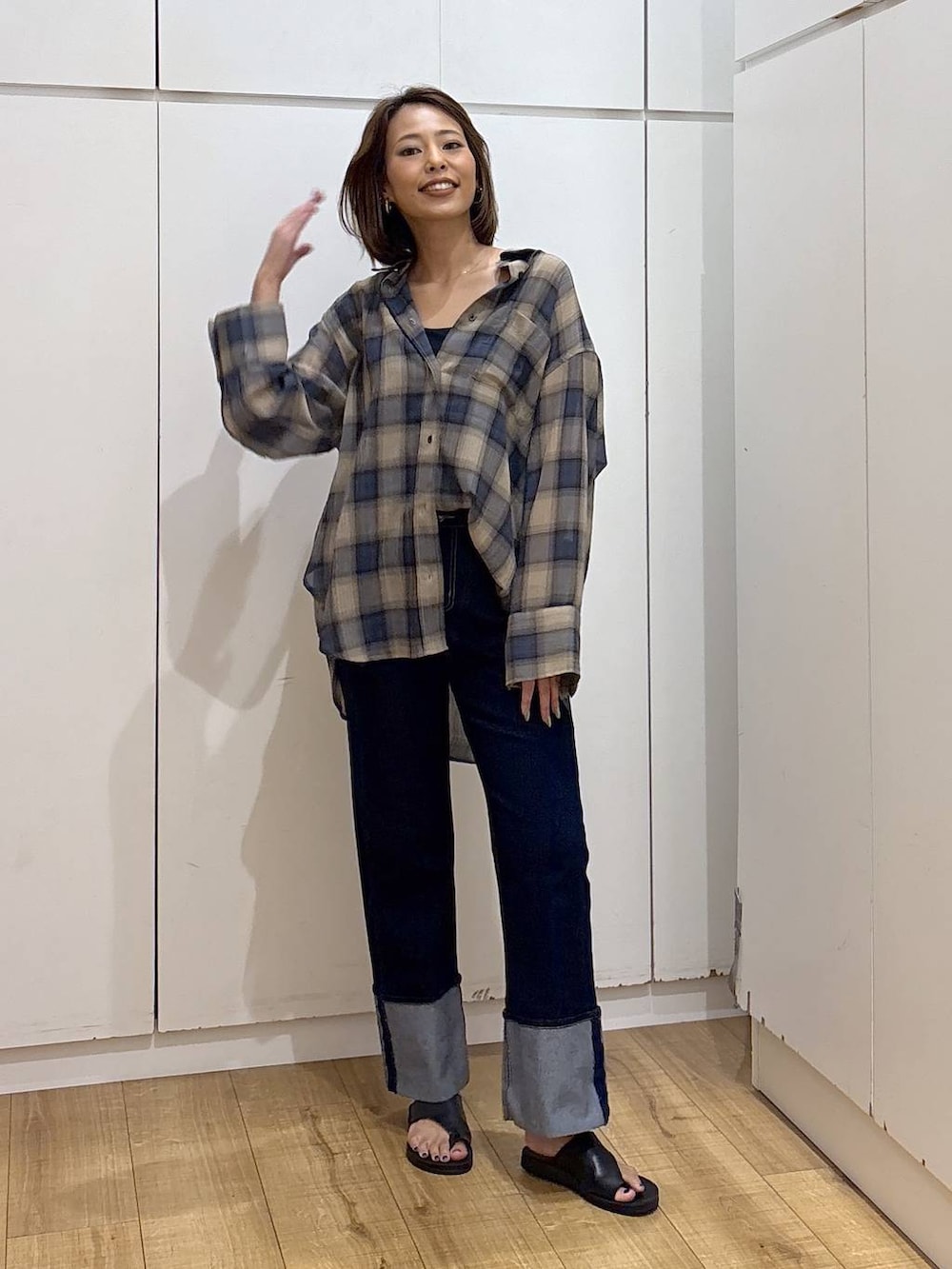 ブルー系のデニムパンツ、ブラック系のキャミソール、ベージュ系のシャツ/ブラウスを着用したレディースの夏コーディネートの3枚目の写真
