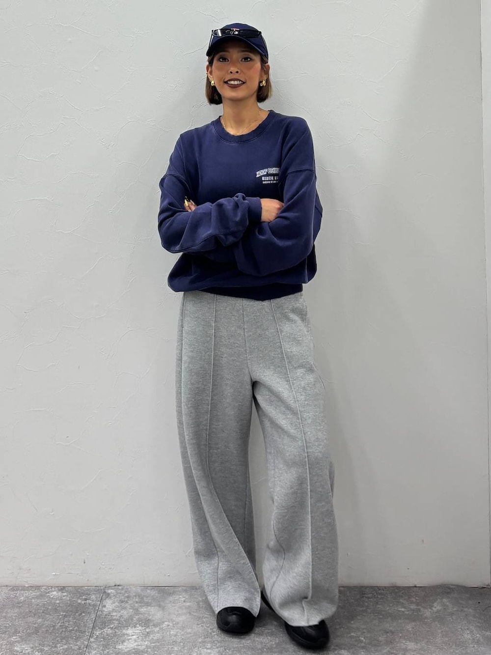 ブラック系のスニーカー、グレー系のその他パンツ、ブルー系のキャップを着用したレディースの秋コーディネートの2枚目の写真