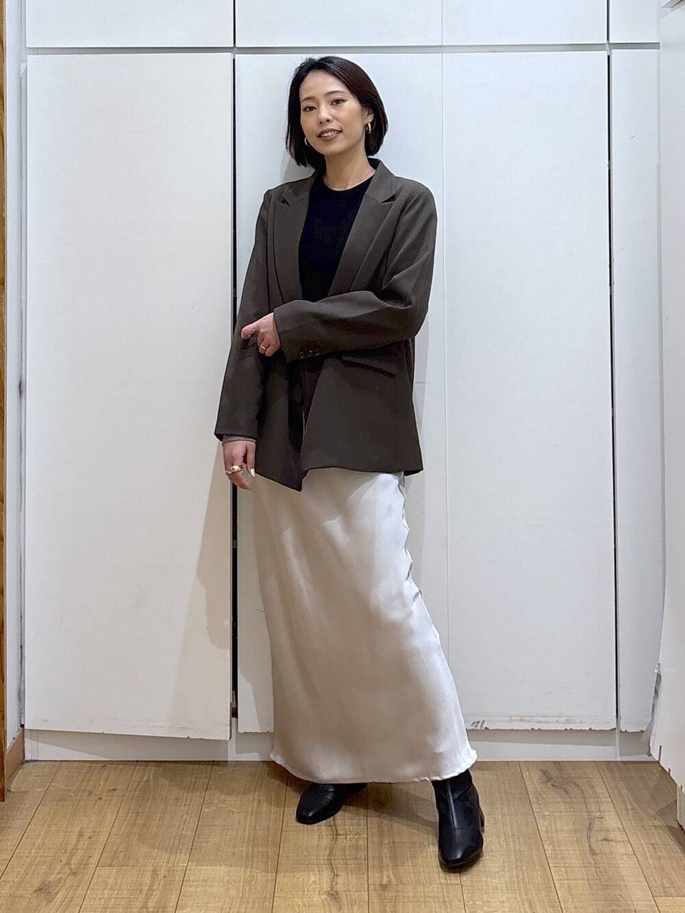 ブラック系のブーツ、ブラウン系のテーラードジャケット、グレー系のスカートを着用したレディースの冬コーディネートの2枚目の写真